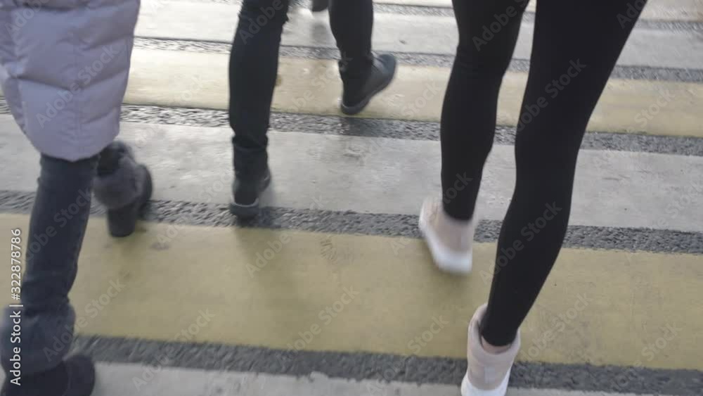 urban residents in casual clothes cross street walking along wet pedestrian crosswalk in city centre first point view urban residents in casual clothes cross street walking along wet pedestrian crosswalk in city centre first point view