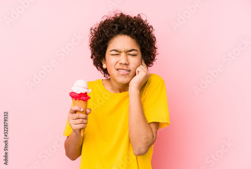 Kid boy holding an ice cream isolated covering ears with hands.