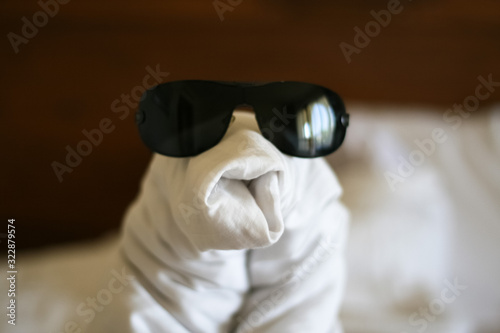 Towel set swan decoration bed in hotel. Swan in sunglasses