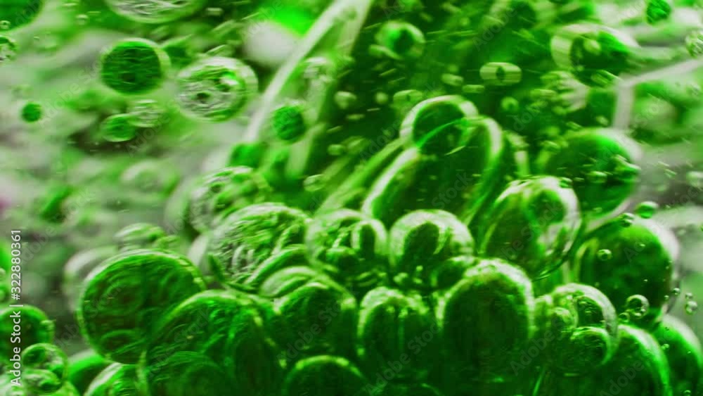 macro shot of green bubbles getting mixed in water, moving around macro shot of green bubbles getting mixed in water, moving around