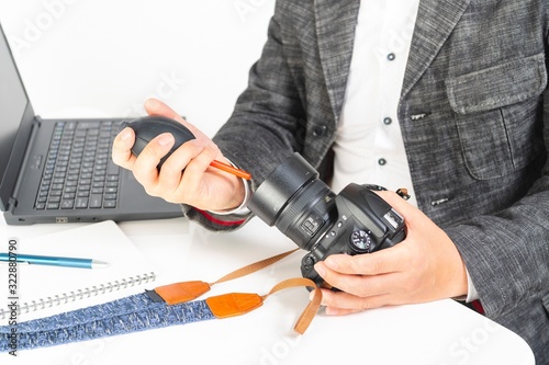 デジタルカメラのレンズを掃除する男性