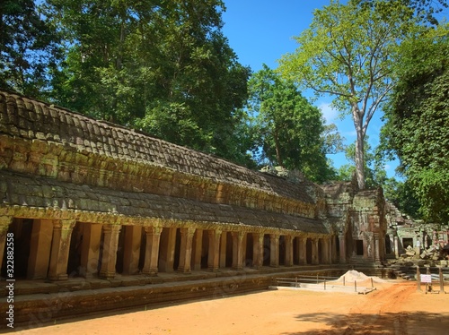 Inner gallery and courtyard of Ta Prohm temple ruins, located in the Angkor Wat complex near Siem Reap, Cambodia. Archeological and restoration scaffoldings can be seen on the background.