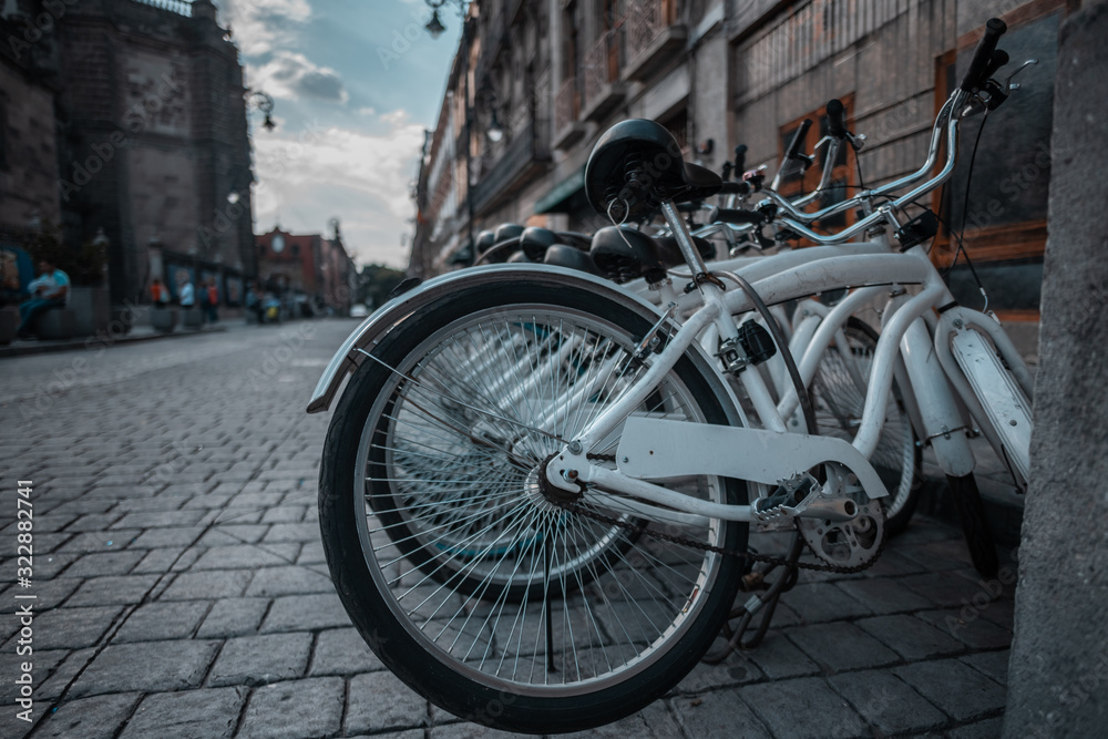 Street photography of white bicycles on the street in the historic center of Mexico City, where old city buildings are appreciated