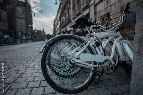 Street photography of white bicycles on the street in the historic center of Mexico City, where old city buildings are appreciated