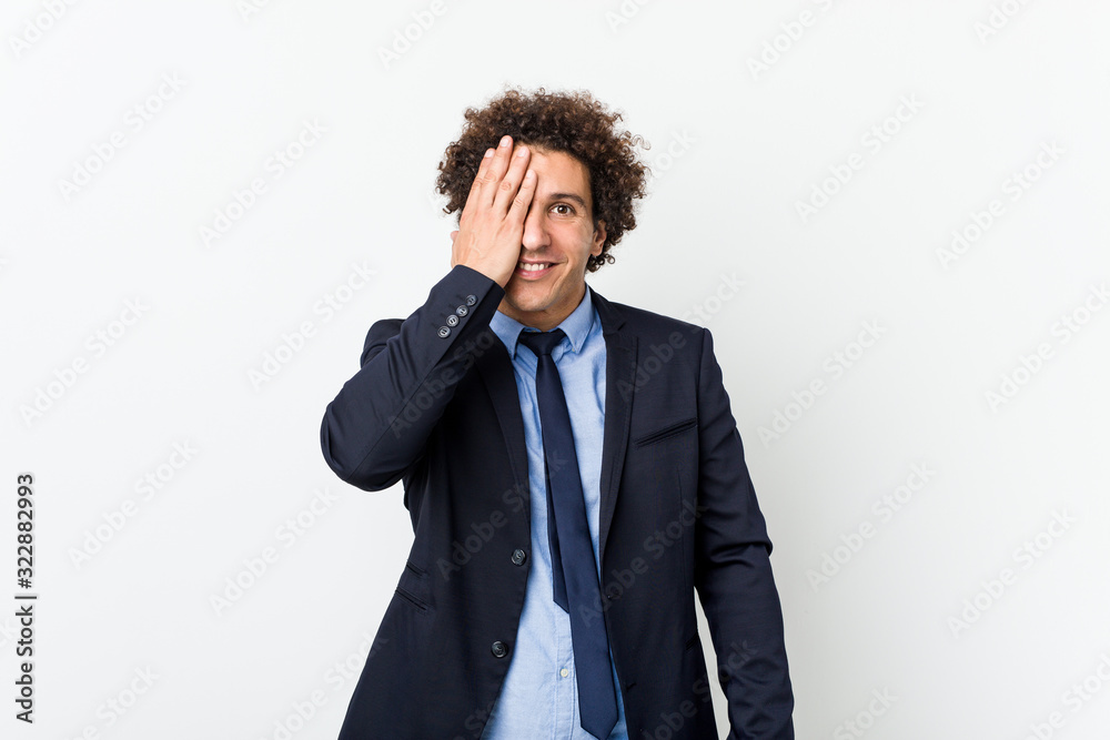 Young business curly man against white background having fun covering half of face with palm. Young business curly man against white background having fun covering half of face with palm.