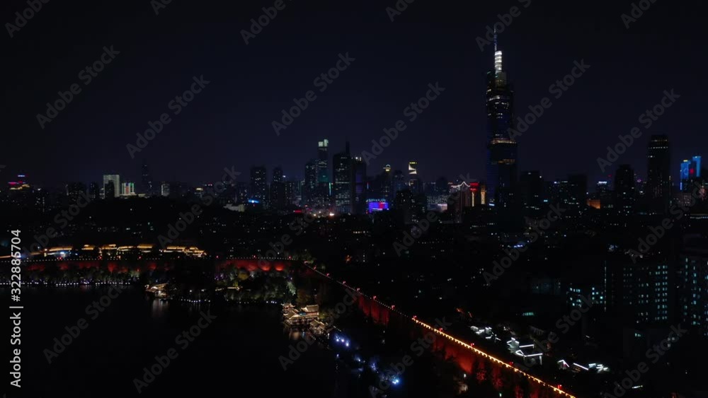 flight over nanjing city night illuminated lakeside wall park downtown tower aerial panorama 4k china flight over nanjing city night illuminated lakeside wall park downtown tower aerial panorama 4k china