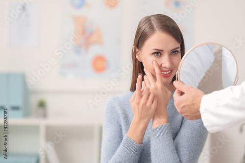 Woman putting contact lenses in eyes at ophthalmologist's office