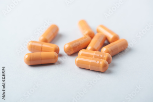 HMB (β-Hydroxy β-methylbutyric acid) capsules. Bodybuilding food supplements on bright paper background. Close up. 