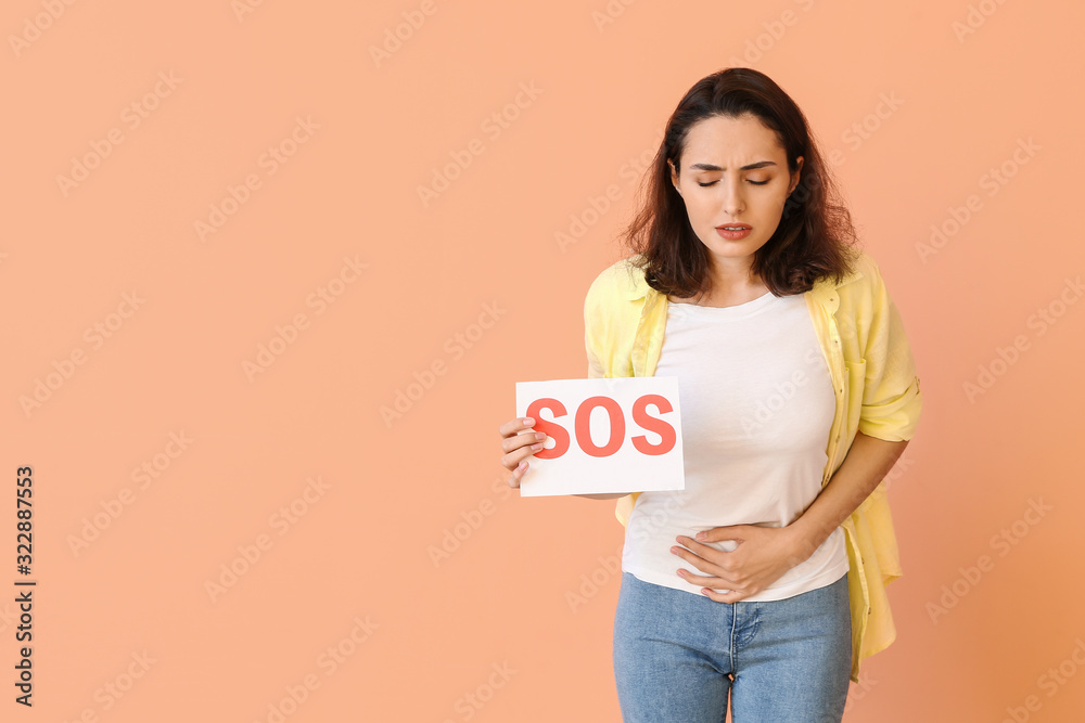 Young woman suffering from menstrual cramps on color background Young woman suffering from menstrual cramps on color background
