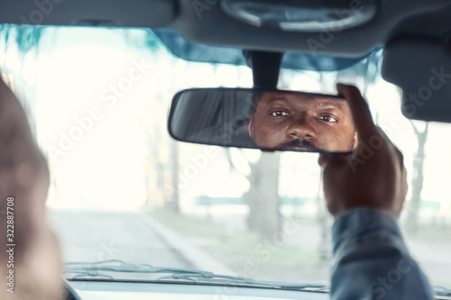 Foto Driver adjusting rear view mirror in car