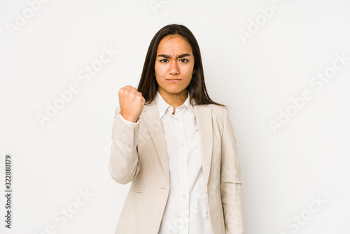 Young woman isolated on a white background showing fist to camera, aggressive facial expression.