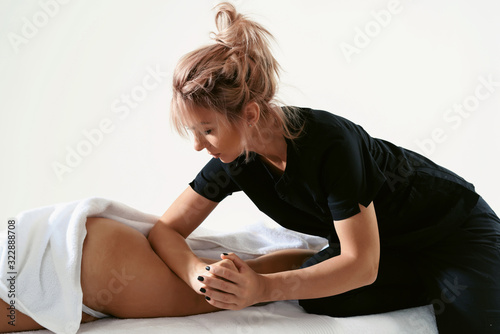 Fat burning massage. masseur making anti cellulite massage for young woman in wellness center or beauty salon. Perfect skin beauty concept