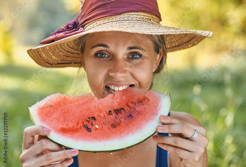 beautiful woman eating watermelon in summer in park