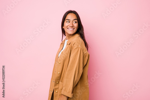 Young mixed race indian woman isolated looks aside smiling, cheerful and pleasant. © Asier