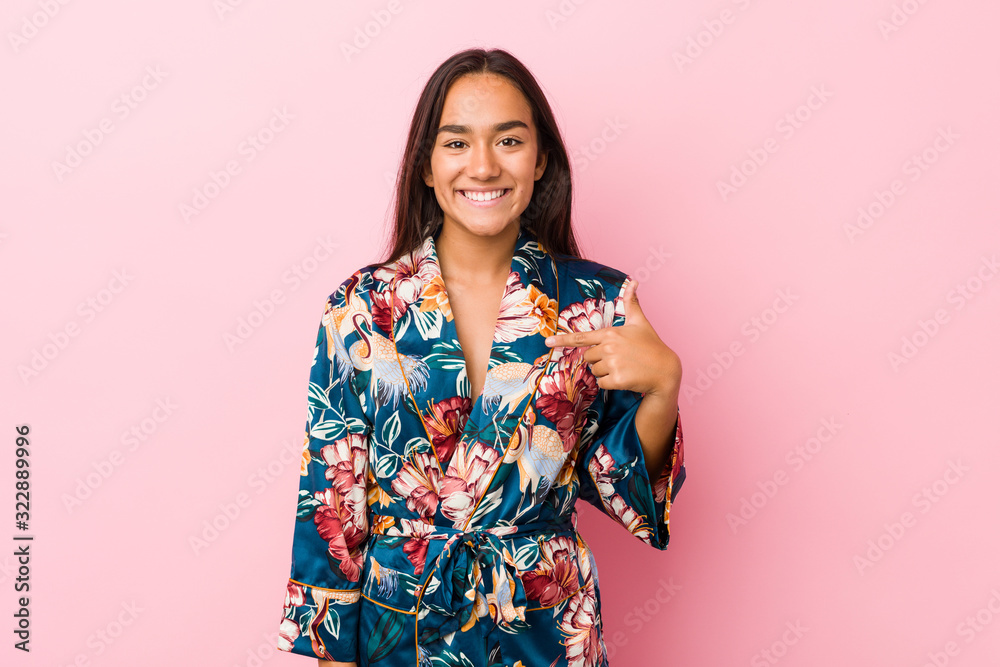 Young indian woman wearing a kimono pajama person pointing by hand to a shirt copy space, proud and confident Young indian woman wearing a kimono pajama person pointing by hand to a shirt copy space, proud and confident
