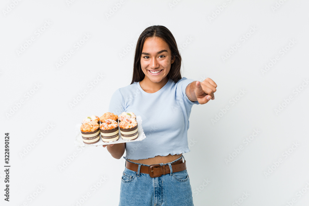 Young mixed race indian holding a sweet cakes cheerful smiles pointing to front. Young mixed race indian holding a sweet cakes cheerful smiles pointing to front.
