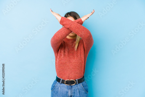 young caucasian woman posing isolated keeping two arms crossed, denial concept. photo