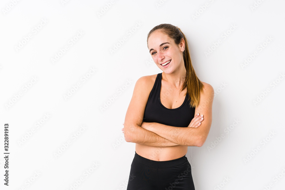 Young caucasian fitness woman posing in a white background laughing and having fun. Young caucasian fitness woman posing in a white background laughing and having fun.
