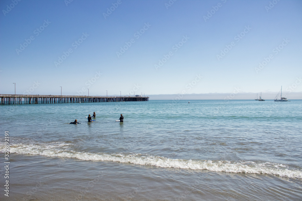 surfers in the ocean at Pismo Beach, California