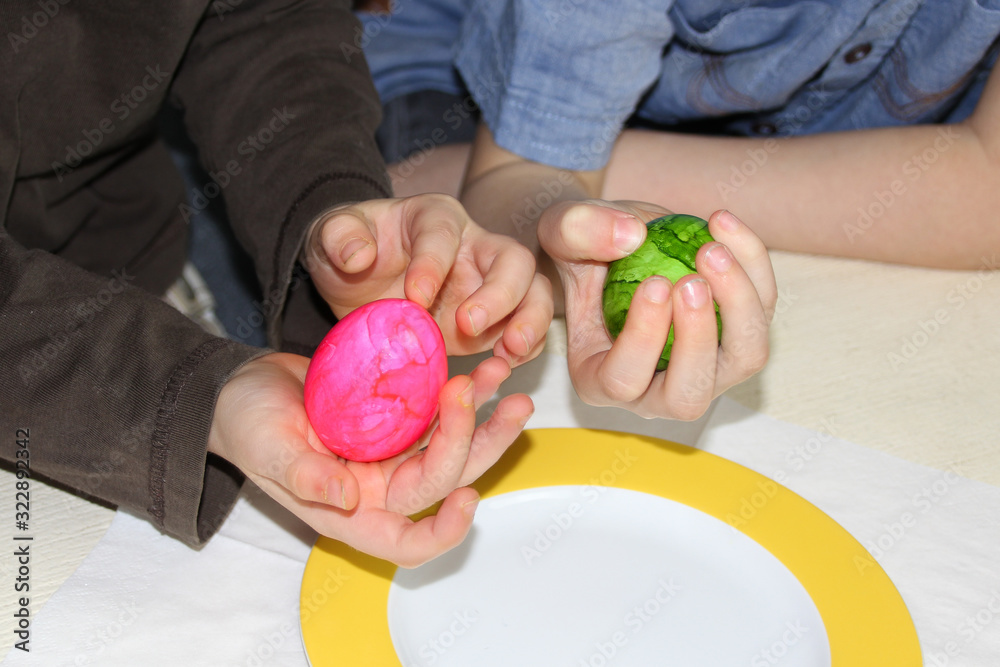 a child holds one green egg in his hand, another has a pink one, the concept of easter fun a child holds one green egg in his hand, another has a pink one, the concept of easter fun