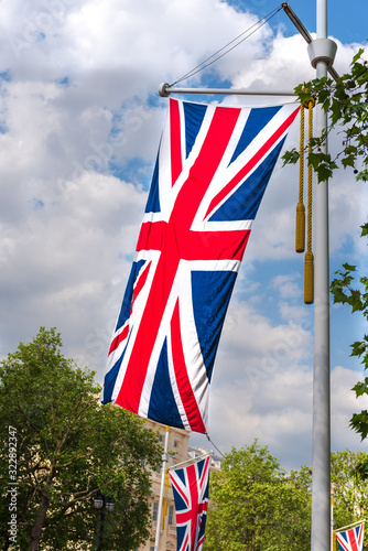 Union Jack flag of the United Kingdom of Great Britain hanging from pole with tassels on the Mall in London