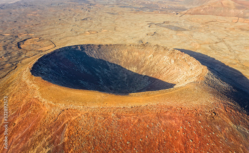 Beautiful panoramic birds eye view on Calderon Hondo, Fuerteventura island. Aerial shooting vulcano around mountains with ocean coastline at sunny day. Travell, Mountains,islands, nature, concept. photo