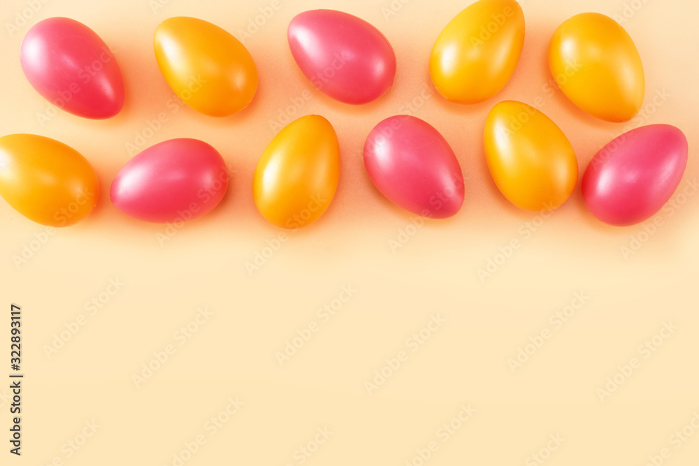 Obraz premium Bright orange and red Easter eggs seeing form above on light background