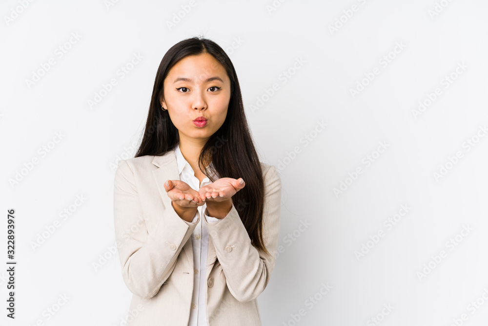 Young business chinese woman isolated folding lips and holding palms to send air kiss.