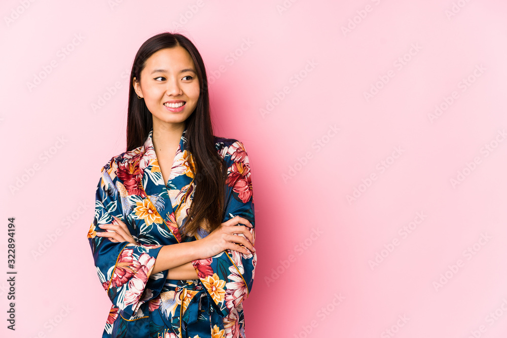 Young chinese woman wearing a kimono pajama isolated smiling confident with crossed arms.