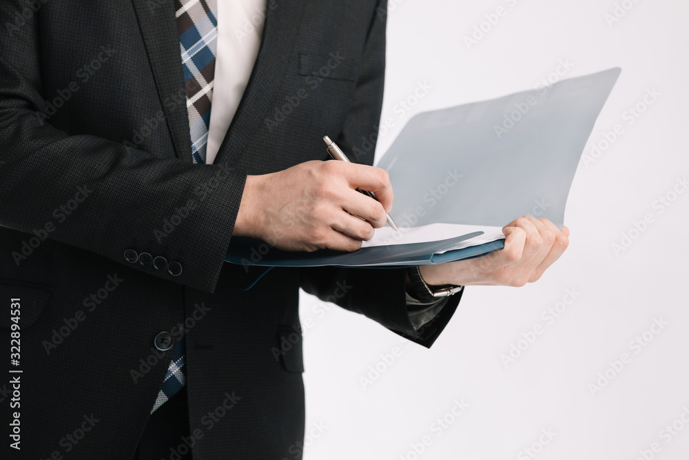 business document. business man, writing on a tablet on a blank sheet. A businessman in a businessman's suit signs a document on a white background. business document. business man, writing on a tablet on a blank sheet. A businessman in a businessman's suit signs a document on a white background.