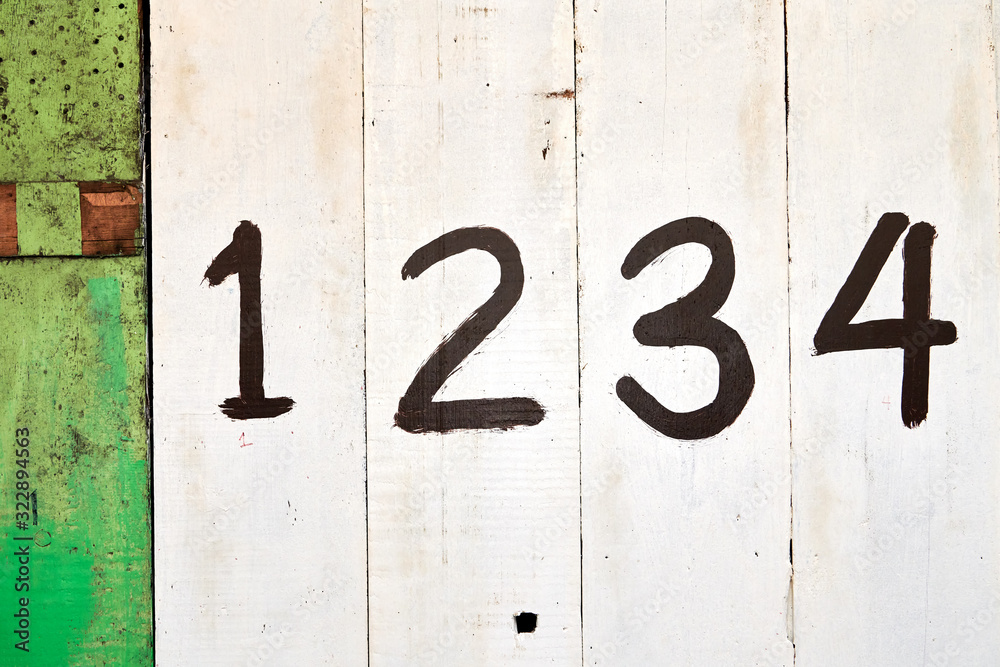 The entrance of a shop is closed with white and green painted wooden panels, which are marked with big numbers, often seen in the Philippines, Asia The entrance of a shop is closed with white and green painted wooden panels, which are marked with big numbers, often seen in the Philippines, Asia