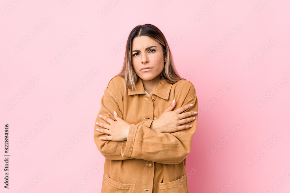 Young caucasian woman isolated going cold due to low temperature or a sickness. Young caucasian woman isolated going cold due to low temperature or a sickness.