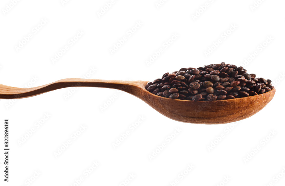 Brown lentils in the wooden spoon isolated on a white background. Brown lentils in the wooden spoon isolated on a white background.