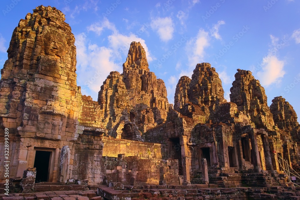 Bayon temple, located in Angkor, Cambodia, the ancient capital city of the Khmer empire. View of the massive stone face towers from the western inner courtyard.
