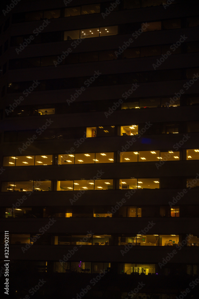Tall building, skyscraper, at night, people at work at the office, overtime.Vertical shot