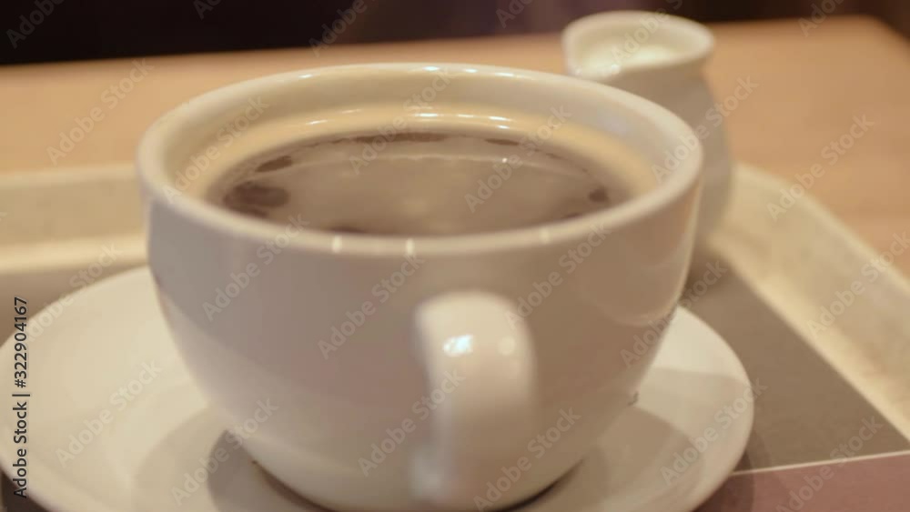 Cup of fresh coffee in a cup with serving of milk