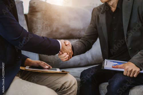 Two confident business man shaking hands during a meeting in the office  success  dealing  greeting and partner in sun light