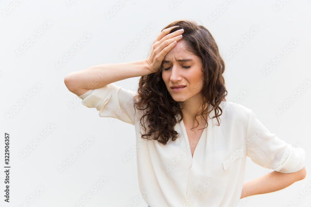 Upset young woman with headache. Sad Caucasian woman with migraine holding hand on head. Headache, migraine concept Upset young woman with headache. Sad Caucasian woman with migraine holding hand on head. Headache, migraine concept