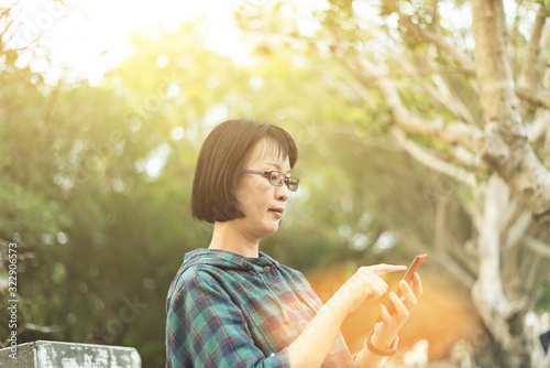 Asian mature woman using cellphone photo
