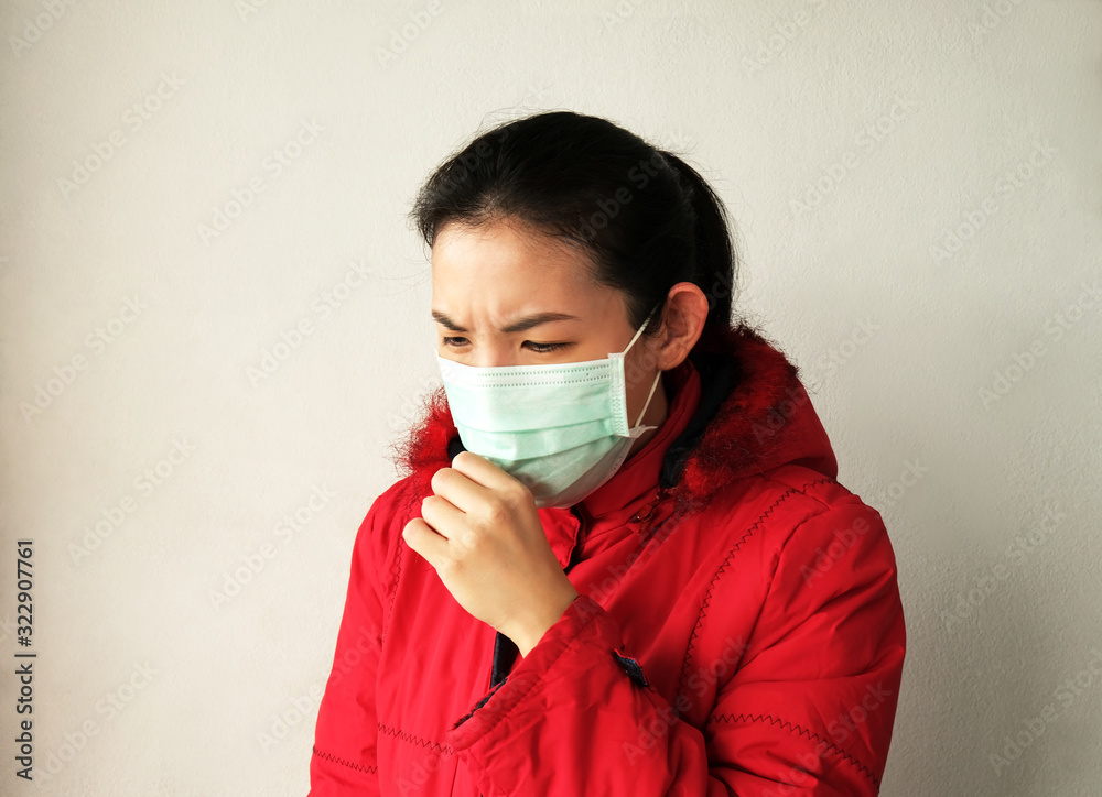Asian woman wearing face mask and coughing on white wall background. Concept for air pollution, coronavirus infection and health care. Asian woman wearing face mask and coughing on white wall background. Concept for air pollution, coronavirus infection and health care.