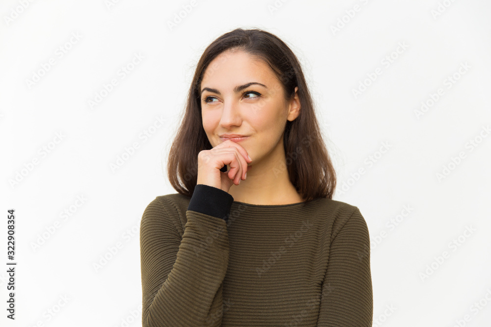 Curious young woman holding hand on chin. Beautiful lady thinking about something and looking aside. Thinking concept Curious young woman holding hand on chin. Beautiful lady thinking about something and looking aside. Thinking concept