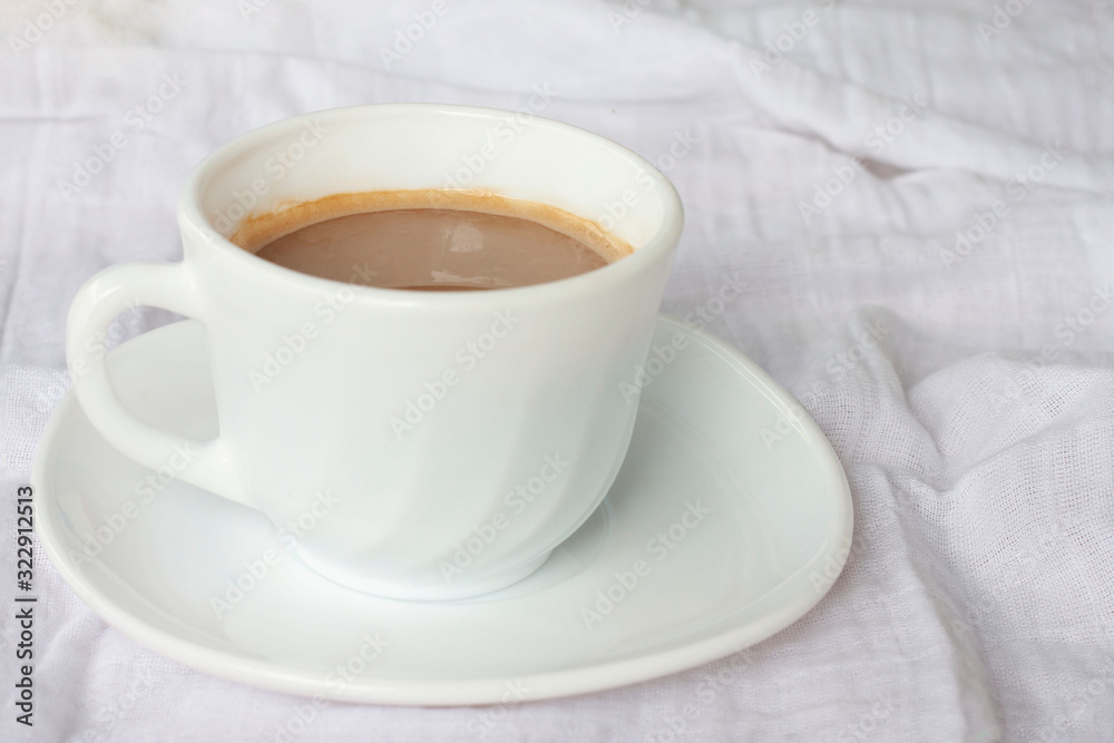 A cup of hot coffee on white tablecloth for the new morning. A cup of hot coffee on white tablecloth for the new morning.