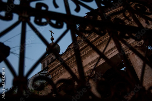 iron gate against the background of the dome of an abandoned church