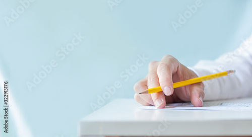high school,university student study.hands holding pencil writing paper answer sheet.sitting lecture chair taking final exam attending in examination classroom.concept scholarship for education abroad