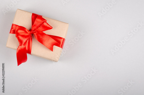 Gift box on gray background composition, present with ribbon and bow.