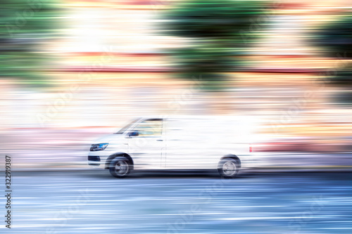 White van speeding down a city street. © Finmiki