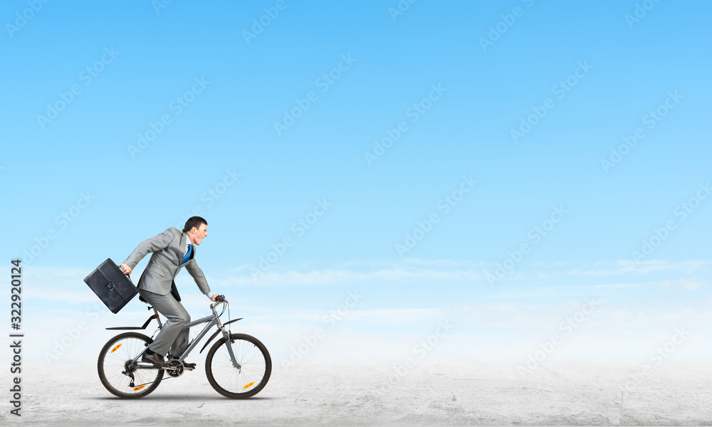 Fototapeta premium Man wearing business suit riding bicycle outdoor.