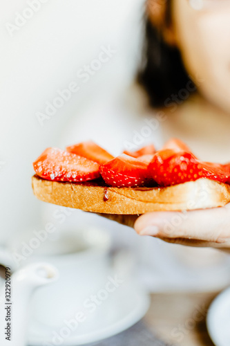 Sandwich with sliced strawberries and chocolate spead. 