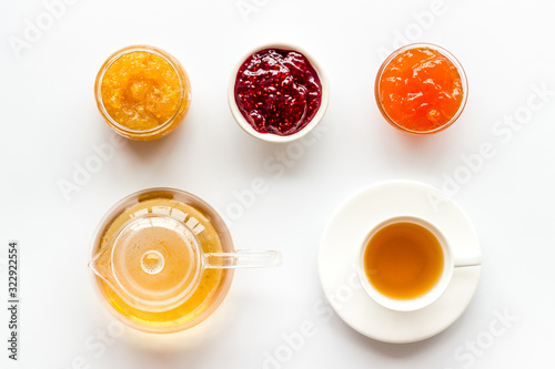 Fruit jam near tea on white kitchen desk