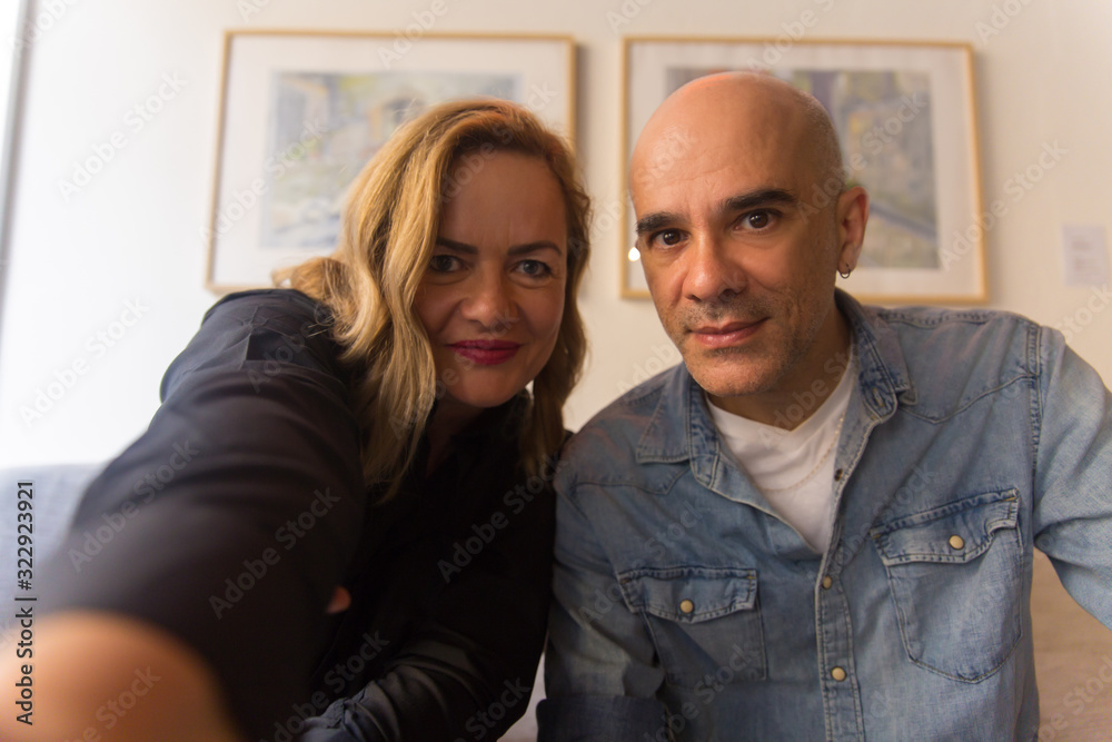 Smiling mature couple posing for self portrait. Cheerful middle aged people looking at camera. View from camera. Self portrait concept Smiling mature couple posing for self portrait. Cheerful middle aged people looking at camera. View from camera. Self portrait concept